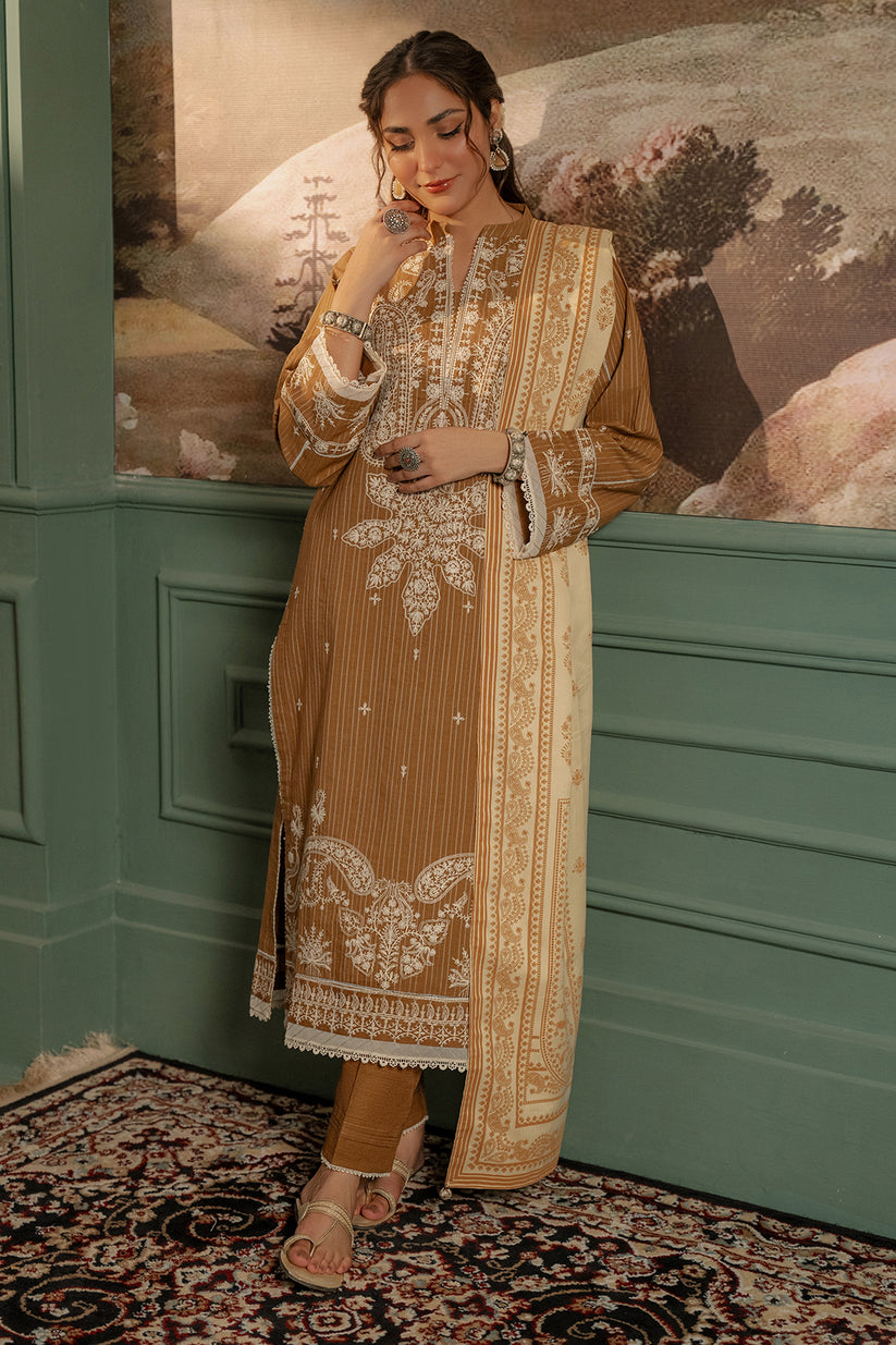 Woman in a traditional embroidered outfit standing in a room with decorative walls and rug.