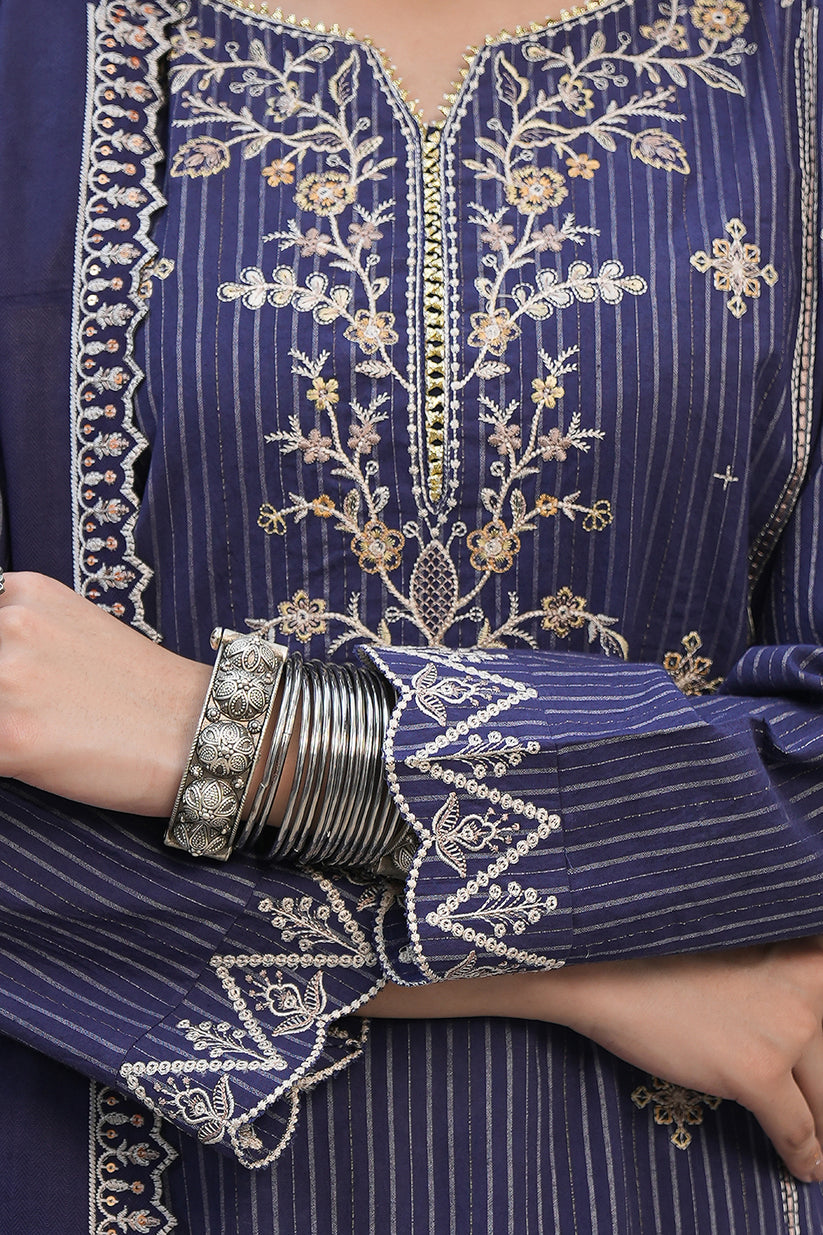 Navy blue embroidered garment with gold detailing, worn by a person.