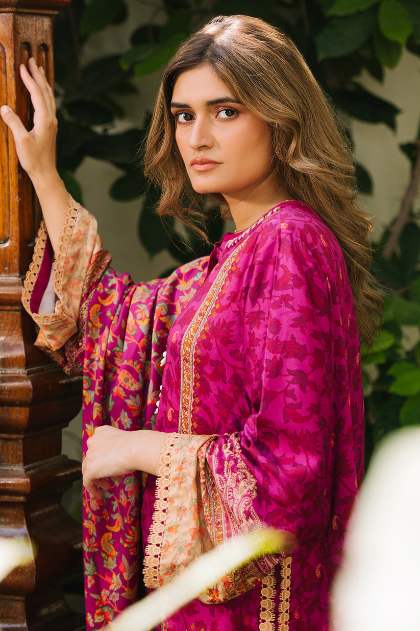 Woman wearing a vibrant pink and gold traditional outfit with a blurred background