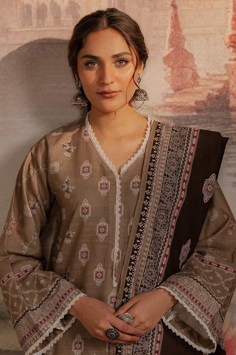 Woman wearing a traditional embroidered outfit with a blurred architectural background