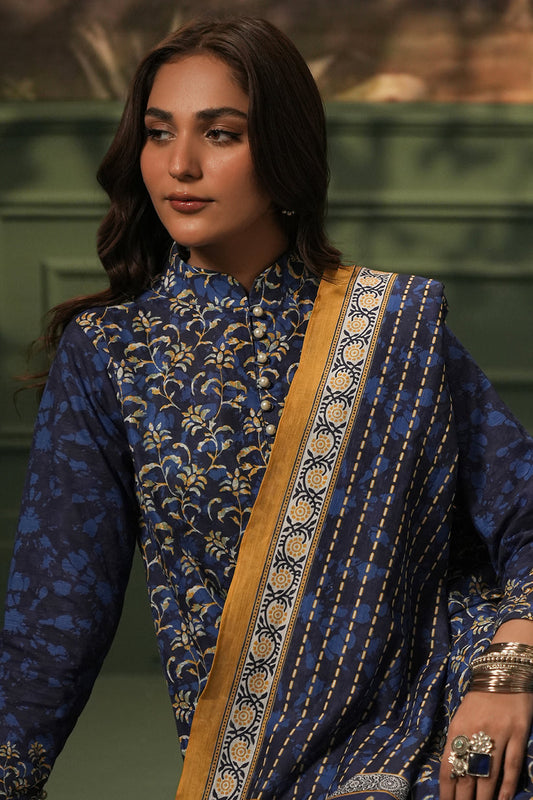 Woman wearing a blue traditional outfit with a gold sash against a green background