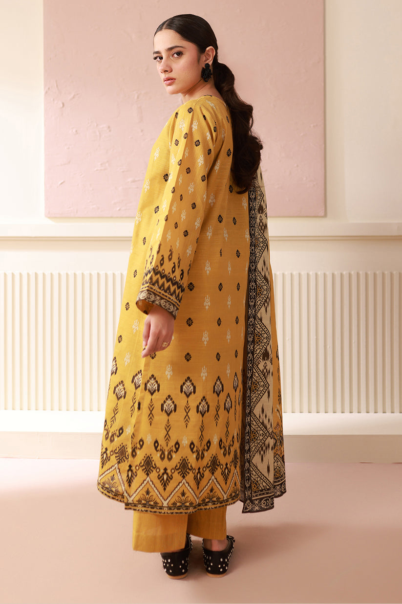 Woman wearing a yellow patterned outfit with a plain background