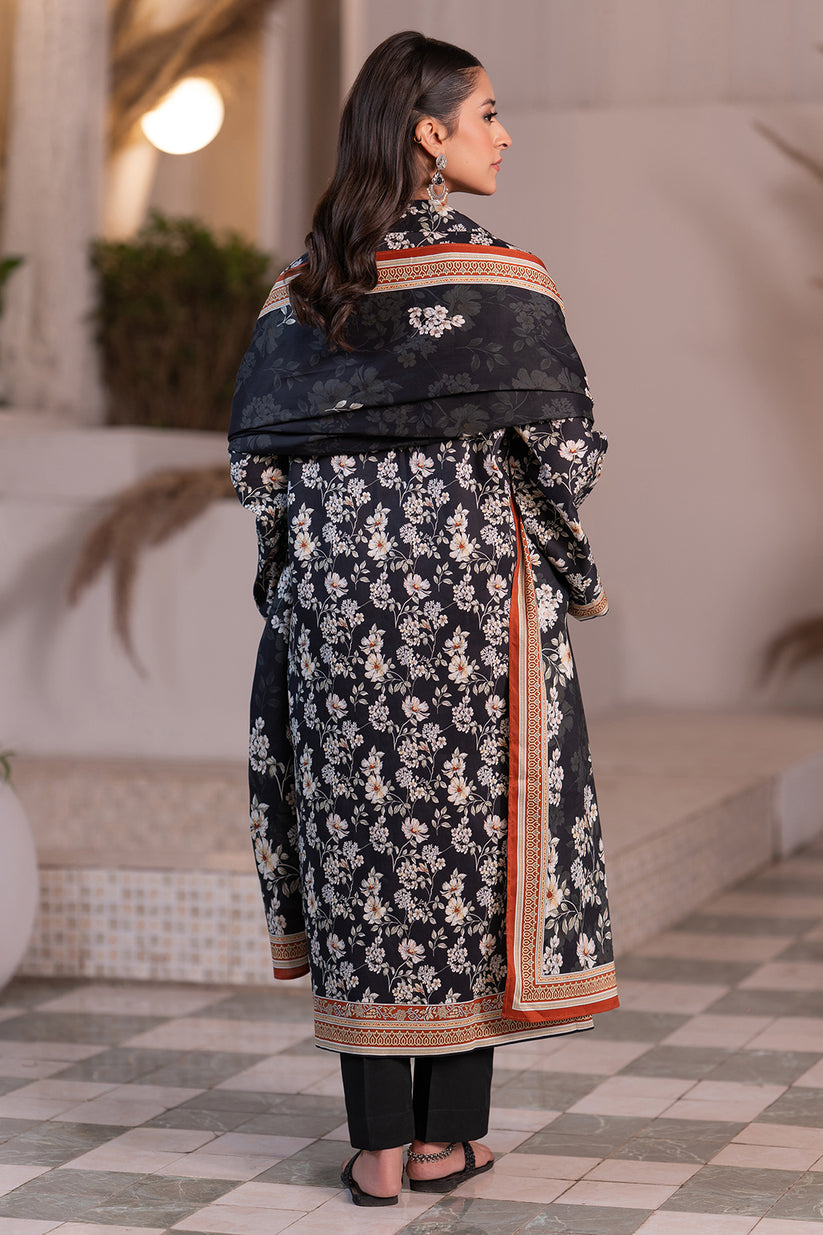 Woman wearing a black floral dress with a matching shawl in an outdoor setting.