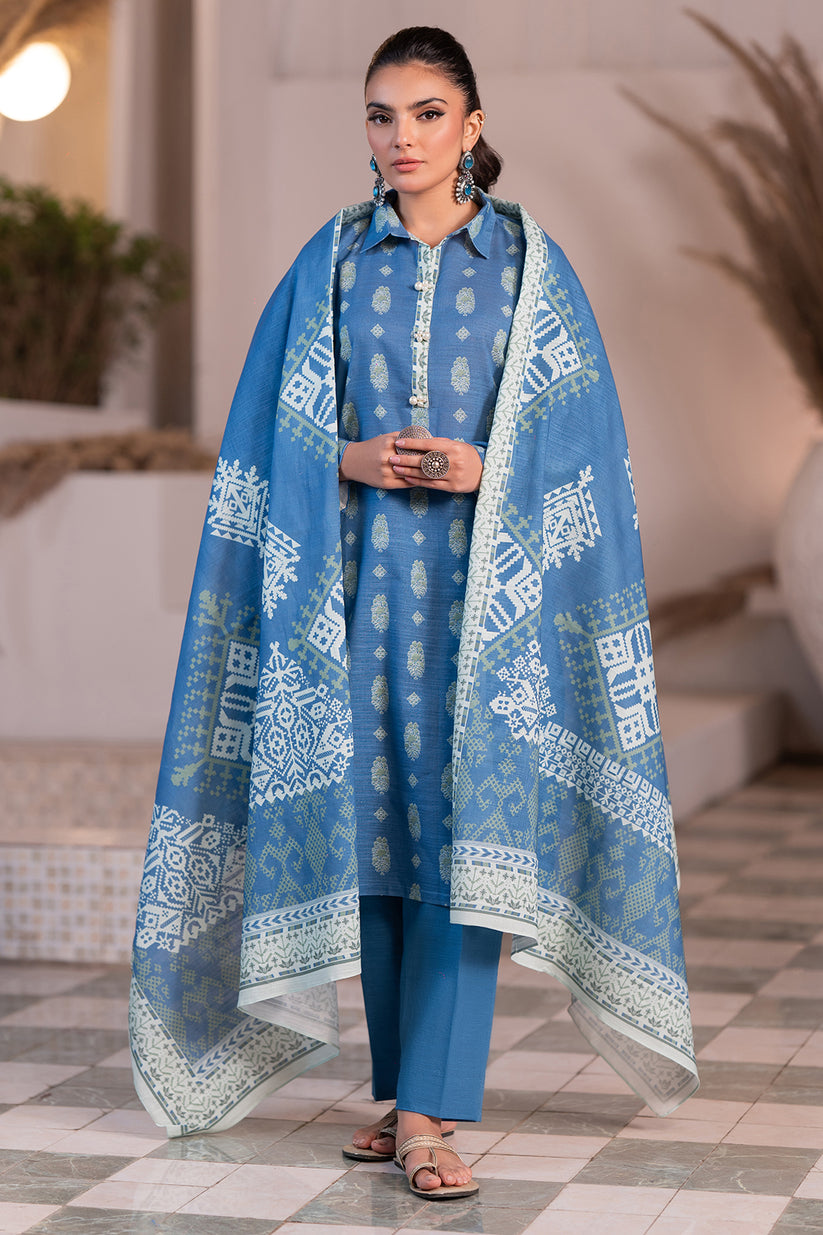 Woman wearing a blue traditional outfit with a patterned dupatta indoors.