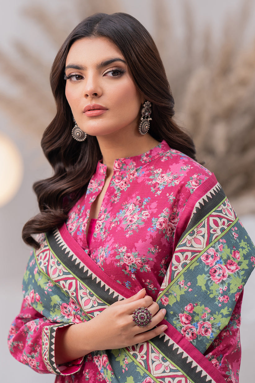 Woman wearing a pink floral saree with a green border against a neutral background